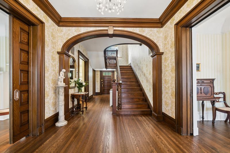 Grand foyer with arched doorway and the front staircase